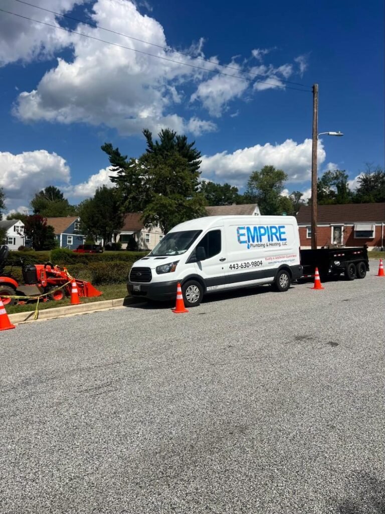 Empire van, trailer and tractor at a water line job with safety cones