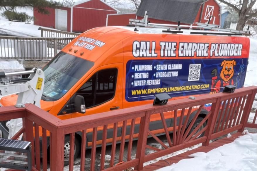Empire Plumbing van parked at a home after a snowfall